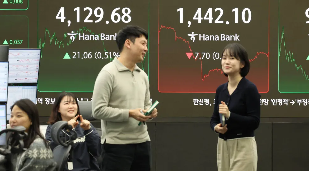 متداولون بجوار شاشة تعرض البيانات المالية في قاعة بنك هانا في سيول (إ.ب.أ)