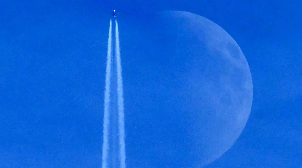 A Boeing 737 Max 8-200 aircraft of Irish budget airline Ryanair flies past the Waxing crescent moon in Frankfurt am Main, western Germany on December 27, 2025. (AFP)