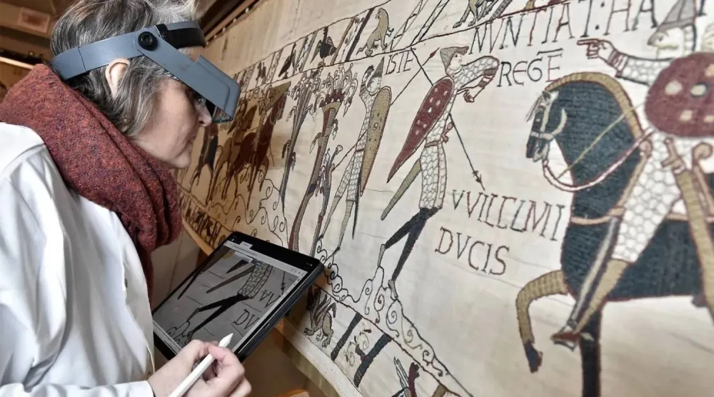 This photo provided by Bayeux townhall shows a technician inspecting the famed Bayeux tapestry in Bayeux, Normandy, in 8th January, 2020. (Ville de Bayeux via AP/File photo)