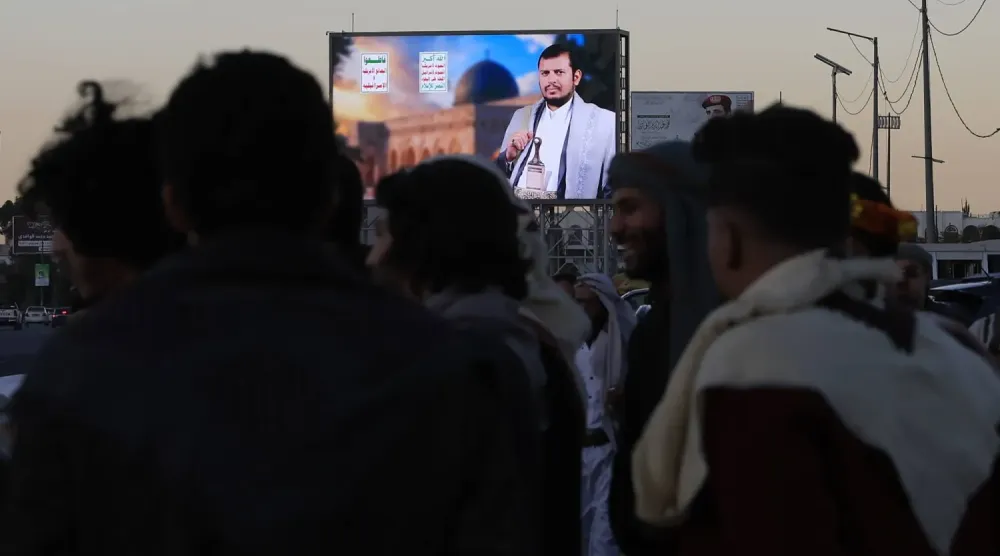 Sana'da Husi liderinin fotoğrafının bulunduğu bir dijital reklam panosunun önünde toplanan insanlar (EPA)