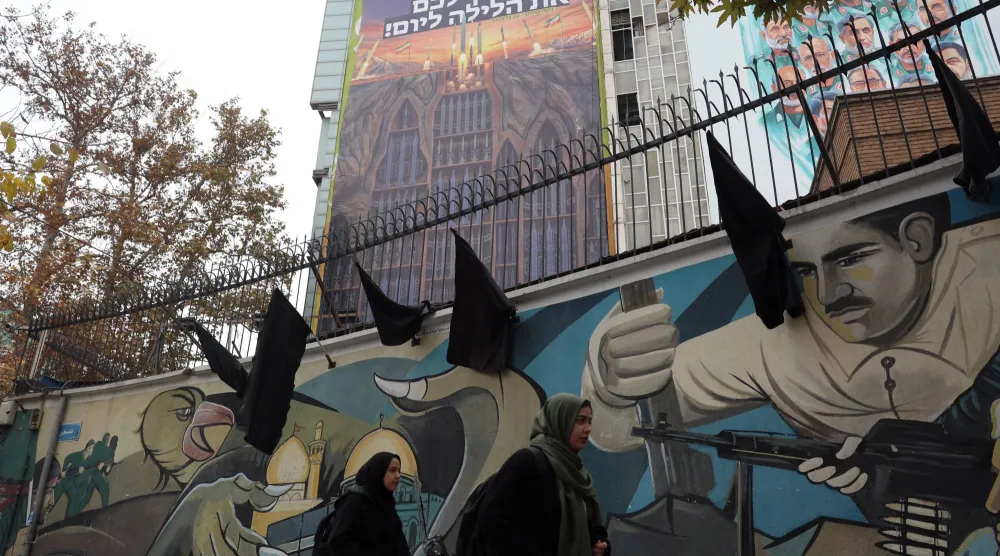 إيرانيتان تمران بجانب لوحة دعائية مناهِضة لإسرائيل تحمل عبارة: «نحن مستعدون... هل أنتم مستعدون؟» معلقة في ساحة وسط طهران (إ.ب.أ)