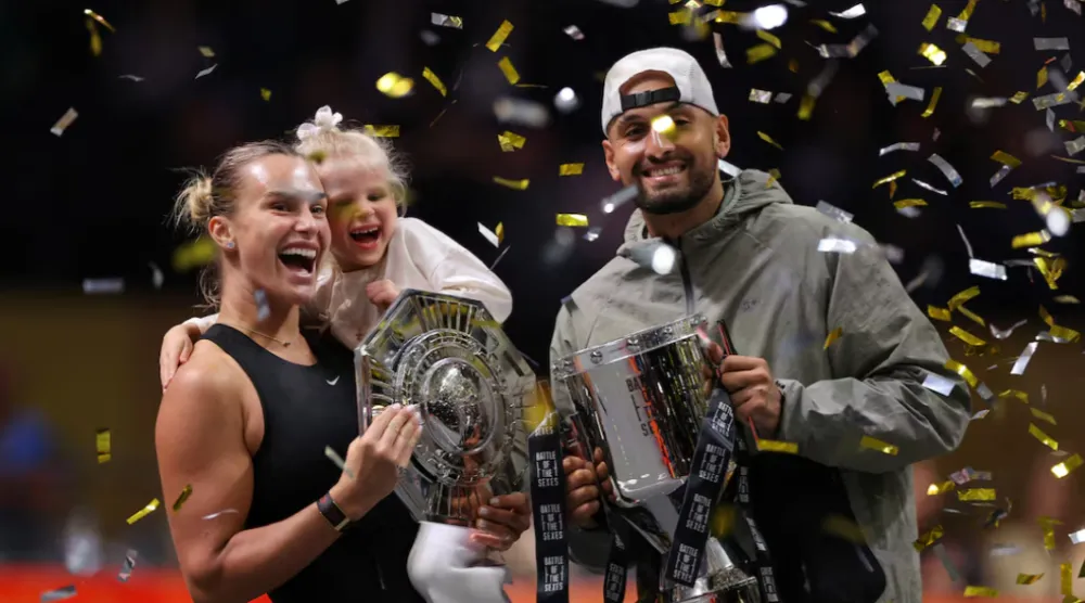  Tennis - 'Battle of the Sexes' - Nick Kyrgios v Aryna Sabalenka - Coca-Cola Arena, Dubai, United Arab Emirates - December 28, 2025 Belarus' Aryna Sabalenka, her goddaughter Nicole, and Australia's Nick Kyrgios celebrate with trophies after the match REUTERS/Amr Alfiky/Pool 