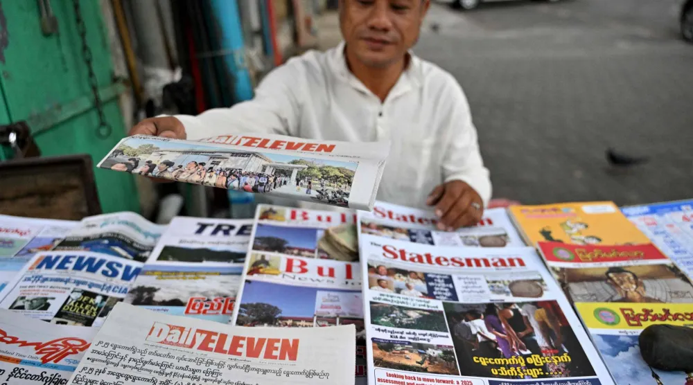 بائع يقوم بترتيب الصحف التي غطت أخبار الانتخابات العامة في ميانمار في يانغون في 29 ديسمبر 2025 (أ.ف.ب)