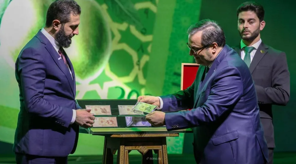 الرئيس السوري وحاكم المصرف المركزي خلال إطلاق العملة الجديدة (سانا)