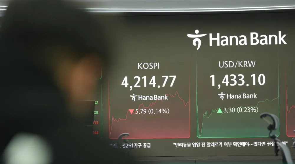 تُظهر شاشة مؤشر كوسبي وسعر صرف الدولار مقابل الوون الكوري في قاعة تداول بنك هانا في سيول (أ.ب)