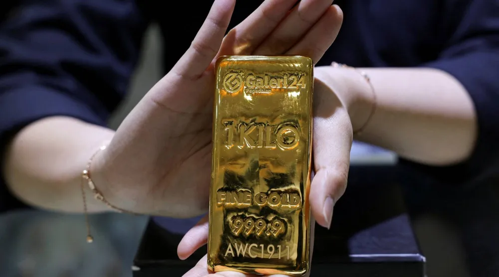 يعرض أحد الموظفين سبيكة ذهبية بوزن كيلوغرام في متجر «غاليري 24» للذهب والمجوهرات في جاكرتا (رويترز)