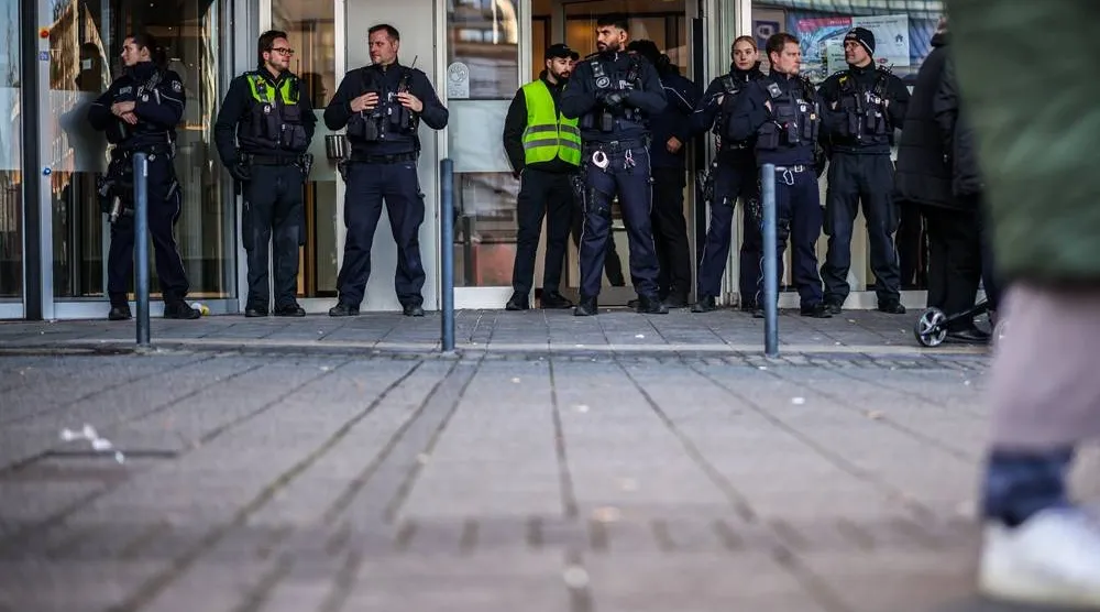  Police officers stand in front of the savings bank branch in the Buer district in Gelsenkirchen, Germany, Tuesday, Dec. 30, 2025 following a break-in into the bank's vault. (Christoph Reichwein/dpa via AP) 