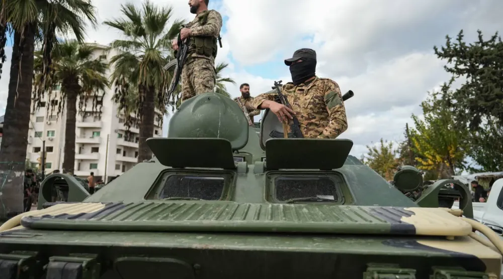 Suriye güvenlik güçleri Lazkiye kentindeki çatışmaların ardından bir askeri aracın üzerinde (EPA)