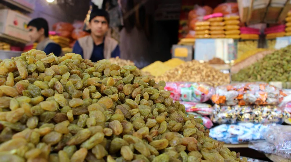 بائع أمام محل للمكسرات في قندهار... وتعد المكسرات أحد أهم المصادر الغذائية الغنية بالزنك (إ.ب.أ)