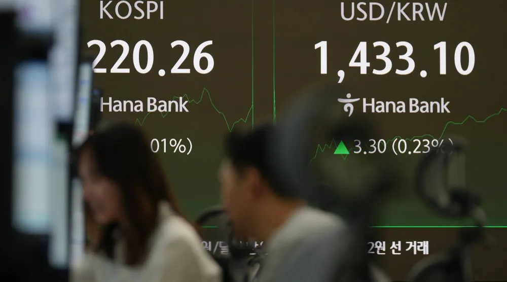 تُظهر الشاشات مؤشر «كوسبي» وسعر صرف الدولار الأميركي مقابل الوون داخل قاعة التداول ببنك هانا في سيول (أ.ب)