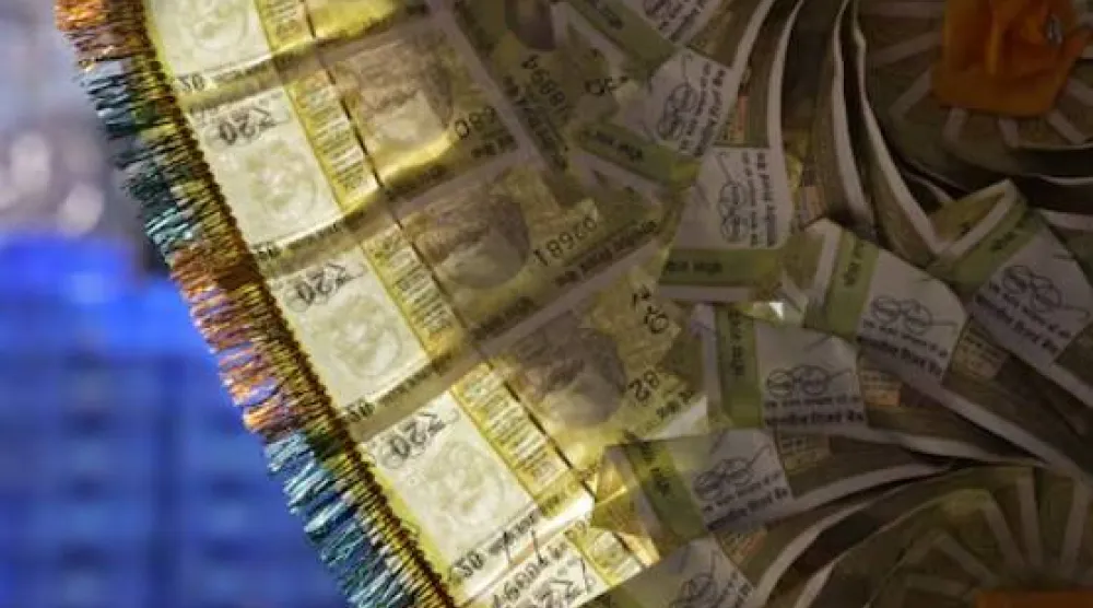 عقد من العملات الهندية معروض عند كاونتر صرف الأموال في الأحياء القديمة بدلهي (رويترز)
