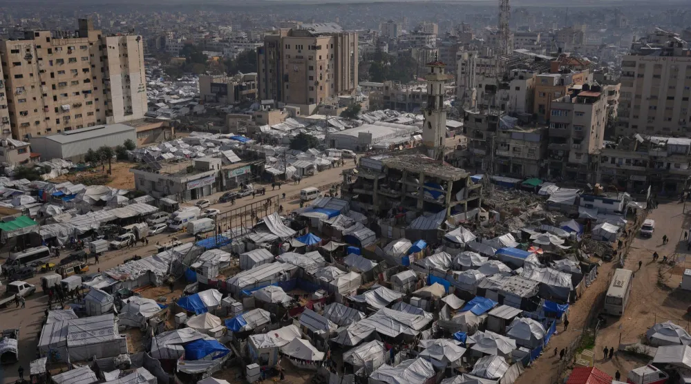 فلسطينيون يسيرون في شوارع مدينة غزة مروراً بمخيمات النازحين (أ.ب)