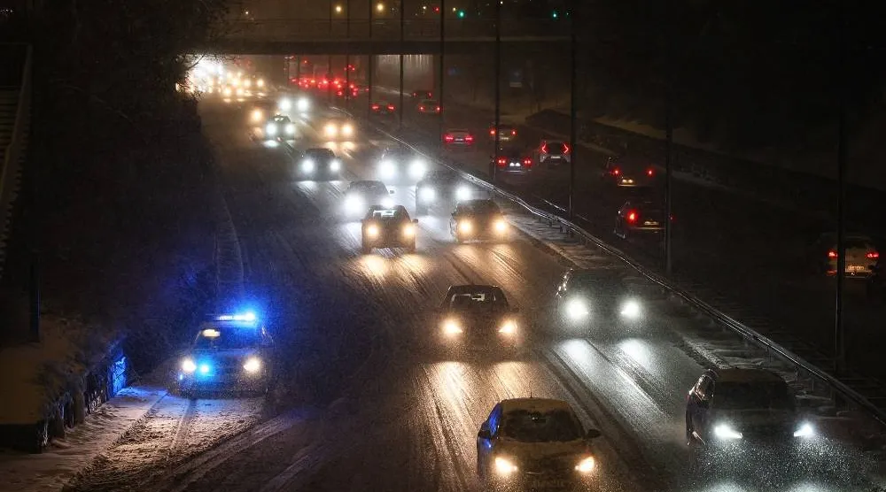 Cars drive on a road during heavy snowfall in central Warsaw, Poland, 30 December 2025. (EPA)