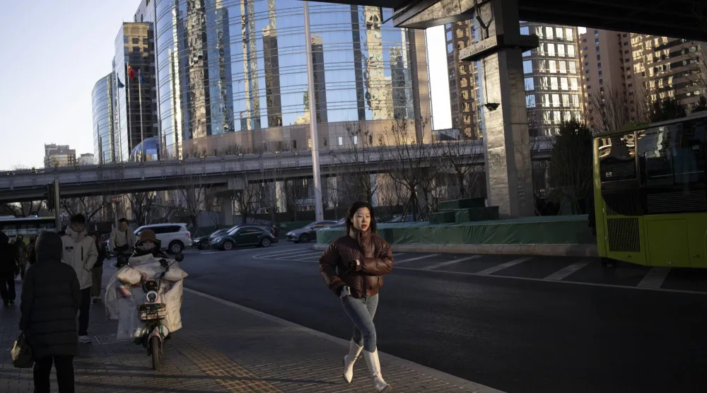 امرأة تجري في أحد شوارع وسط العاصمة الصينية بكين (إ.ب.أ)