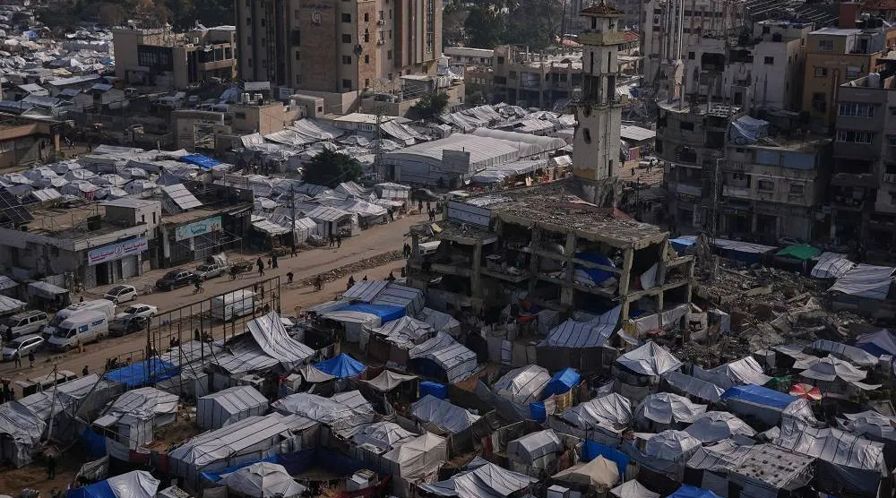 Palestinians walk along streets past tent camps for displaced people in Gaza City, Wednesday, Dec. 31, 2025. (AP)