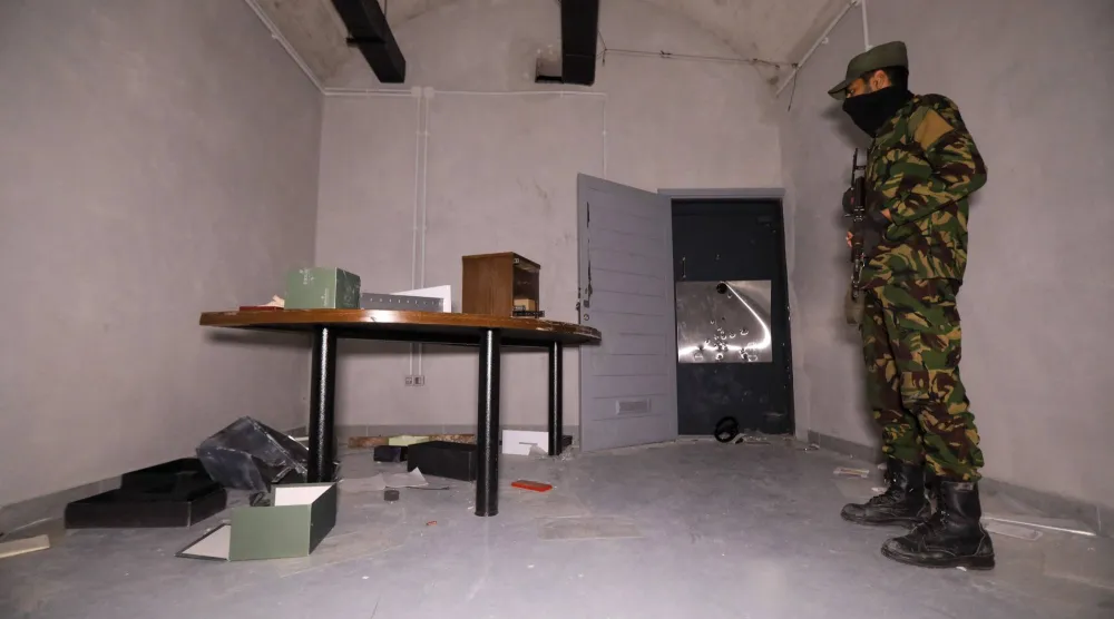 عنصر من قوات الأمن التابعة للسلطات السورية الجديدة في غرفة تحت الأرض بمكاتب ماهر الأسد على مشارف دمشق (أ.ف.ب)