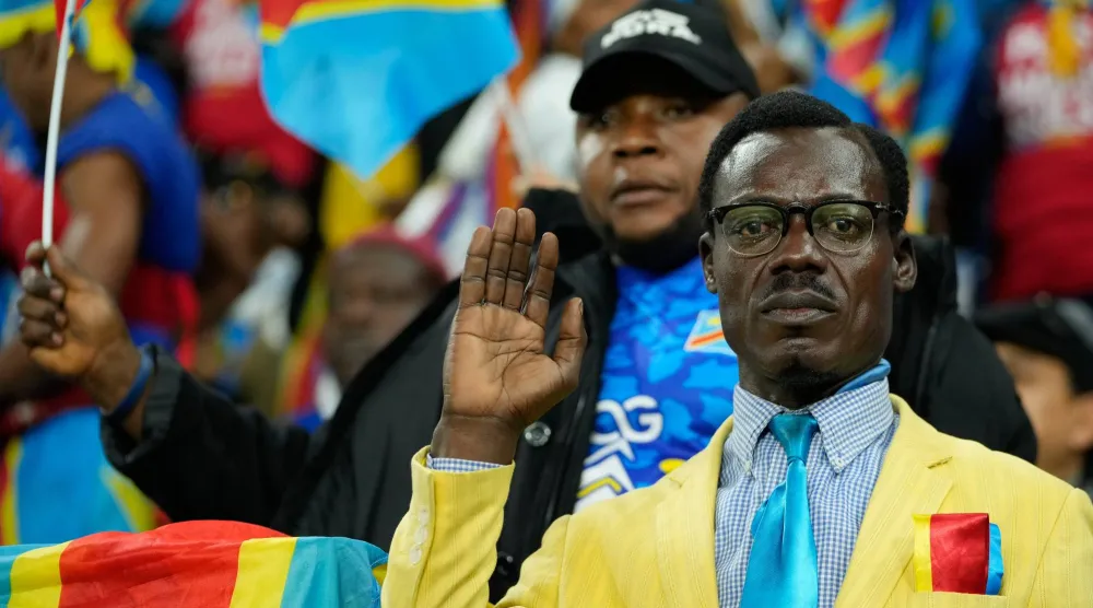 وقف ⁠ميشال ​كوكا ‌مبولادينغا الذي كان يرتدي سترة ورابطة عنق أنيقة ويشبه إلى حد كبير أول رئيس وزراء لبلاده باتريس لومومبا طيلة المباريات (أ.ب)