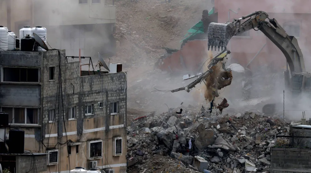 جرافة تابعة للجيش الإسرائيلي تهدم مباني خلال عملية عسكرية في مخيم نور شمس للاجئين (إ.ب.أ)