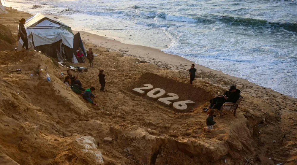 منحوتة رملية للفنان يزيد أبو جراد تمثل العام المقبل حيث يستعد الفلسطينيون النازحون لاستقبال العام الجديد في دير البلح بوسط قطاع غزة (أ.ف.ب)