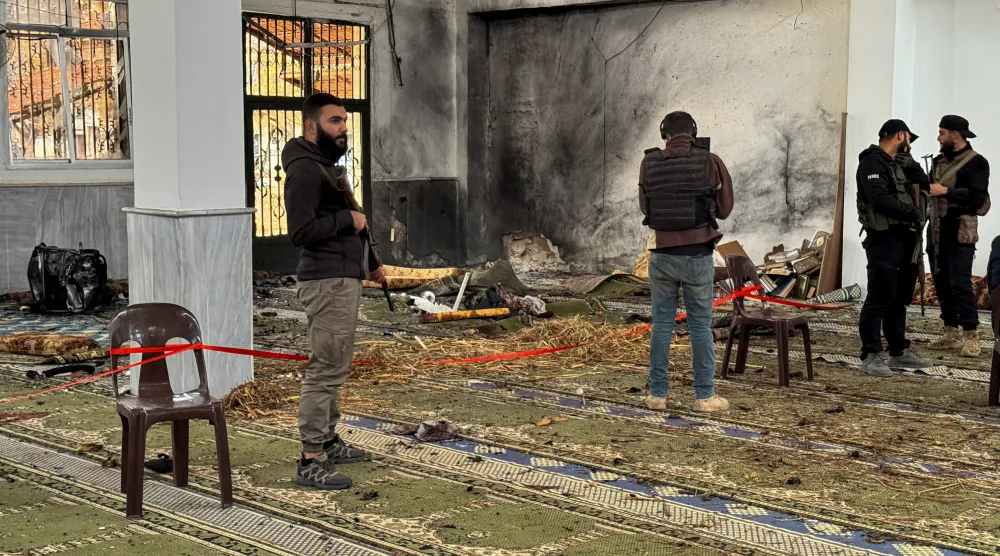 Syrian security forces stand inside a damaged mosque after several people were killed in an explosion at a mosque as the Syrian Arab News Agency (SANA) said, in Homs, Syria December 26, 2025. REUTERS/Ali Ahmed al-Najjar 