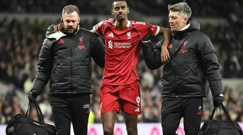 Liverpool's Swedish striker #09 Alexander Isak (C) is helped off the field by medical staff after picking up an injury during the English Premier League football match between Tottenham Hotspur and Liverpool at the Tottenham Hotspur Stadium in London, on December 20, 2025. (Photo by JUSTIN TALLIS / AFP)