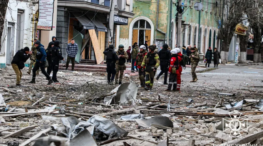 رجال الإنقاذ الأوكرانيون أمام مبنى متضرر نتيجة غارة جوية روسية على مدينة خيرسون (أرشيفية - أ.ف.ب)