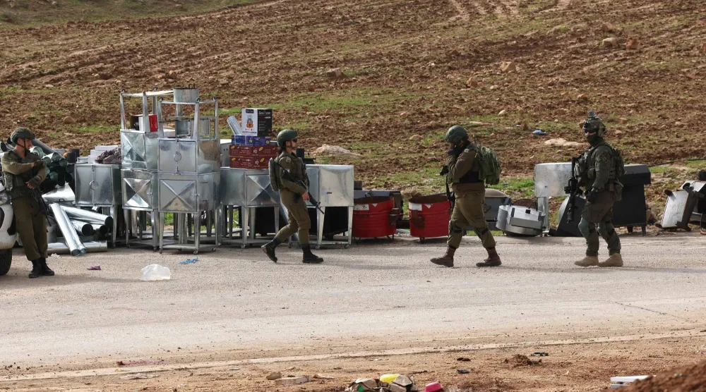 أفراد من قوات الأمن الإسرائيلية عند مدخل قرية السامو الفلسطينية المحتلة في الضفة الغربية بالقرب من مدينة الخليل أمس (أ.ف.ب)