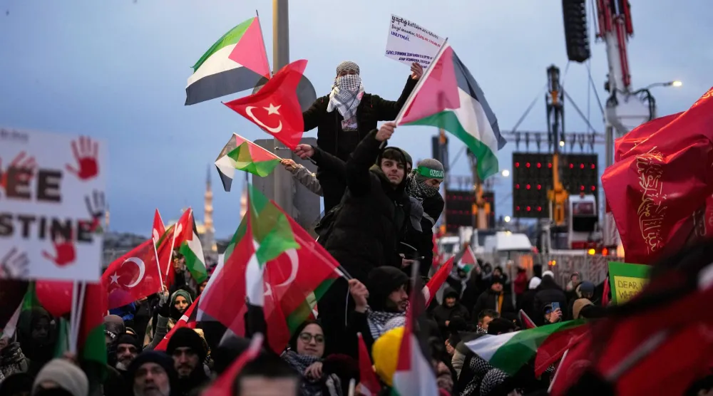 Demonstrators gather on the Galata Bridge holding Palestinian and Turkish flags during a pro-Palestinian rally in Istanbul, Türkiye, Thursday, Jan. 1, 2026. (AP Photo/Khalil Hamra)