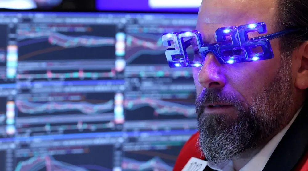 متداول يرتدي نظارات مكتوباً عليها «2026» خلال عمله في قاعة بورصة نيويورك (أ.ف.ب)