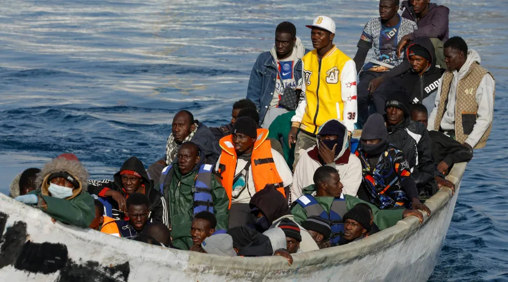 قارب ألياف يحمل مهاجرين يصل إلى ميناء أرجوينجين في جزيرة غران كناريا بإسبانيا (رويترز)