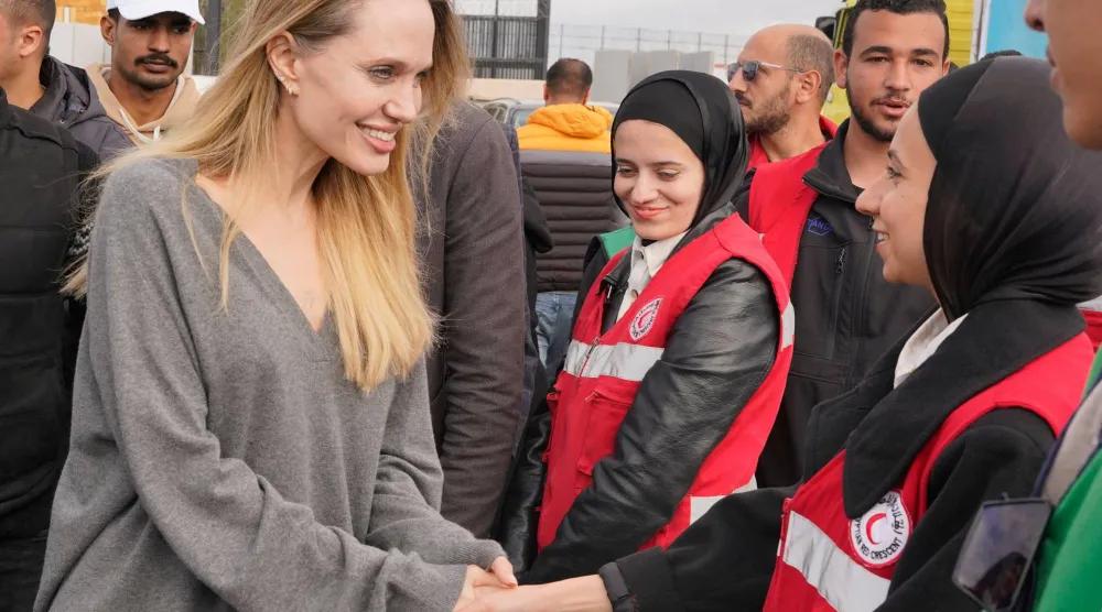 أنجلينا جولي مع كوادر «الصليب الأحمر» في معبر رفح جنوب قطاع غزة أمس (أ.ب)