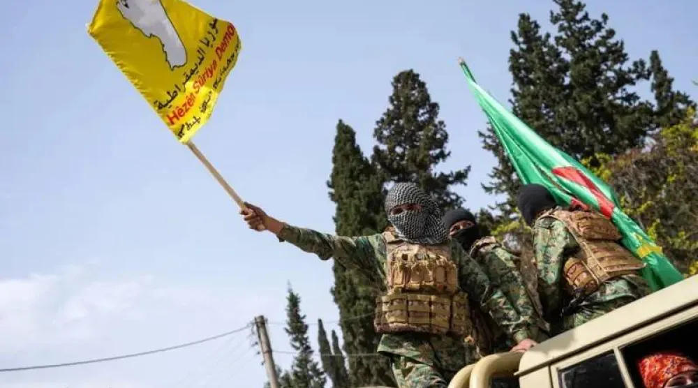 أحد عناصر «قسد» يرفع علمها خلال تحركات في محافظة حلب شمال سوريا أبريل الماضي (إ.ب.أ)