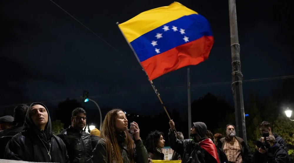 محتجون ضد الضربات الأميركية على فنزويلا يتجمعون أمام السفارة الأميركية في أثينا (أ.ب)