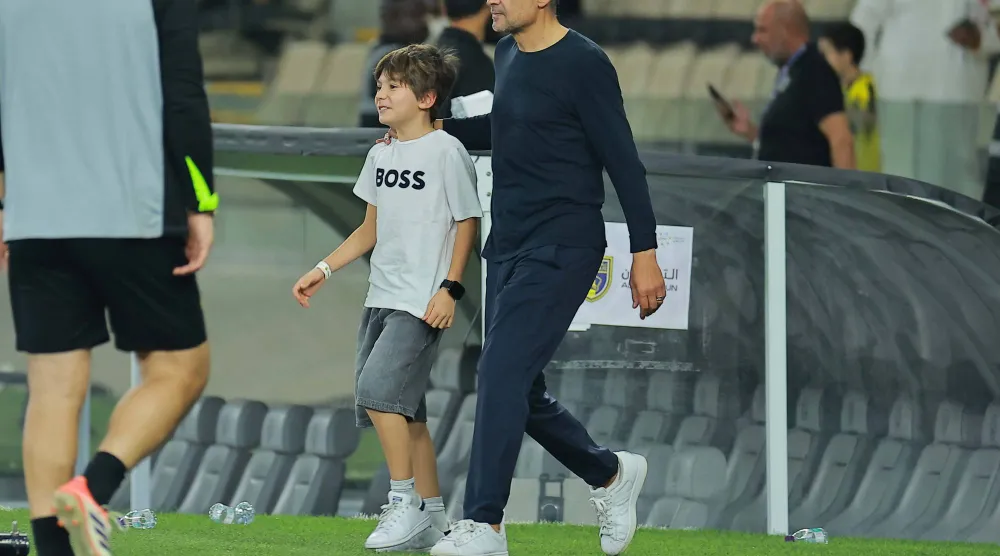 كونسيساو مدرب الاتحاد رفقة طفله بعد المباراة (تصوير: محمد المانع)