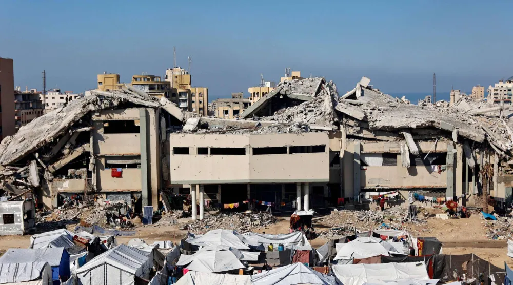 تجمُّع لخيام النازحين الفلسطينيين أمام المباني المدمَّرة للجامعة الإسلامية في مدينة غزة (أ.ف.ب)