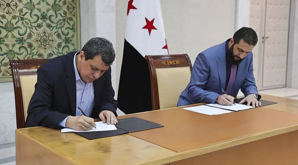 الرئيس السوري أحمد الشرع خلال توقيع اتفاق اندماج «قسد» في الجيش السوري مع قائدها مظلوم عبدي في دمشق يوم 10 مارس الماضي (إ.ب.أ)