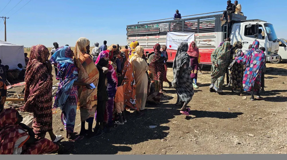 سودانيون فارون من الحرب ينتظرون تلقي المساعدات الإنسانية في مخيم شمال الخرطوم في 30 ديسمبر 2025 (أ.ف.ب)