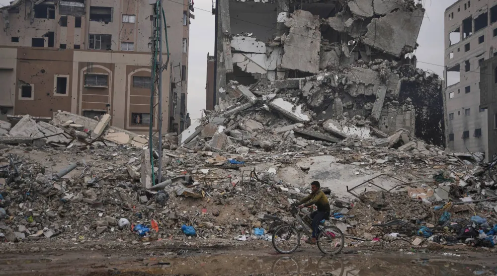 فلسطيني يمر أمام مبنى مدمر في قطاع غزة (أ.ب)