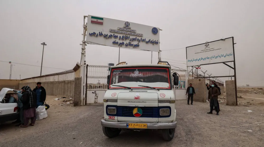 حافلة تقل مهاجرين أفغاناً يتم ترحيلهم لعدم قيامهم بتسوية أوضاعهم القانونية بإيران تغادر مخيماً عند معبر ميلاك الحدودي بالقرب من مدينة زابل في مقاطعة سيستان وبلوشستان الجنوبية الشرقية المتاخمة لأفغانستان يوم 17 ديسمبر 2025 (أ.ف.ب)