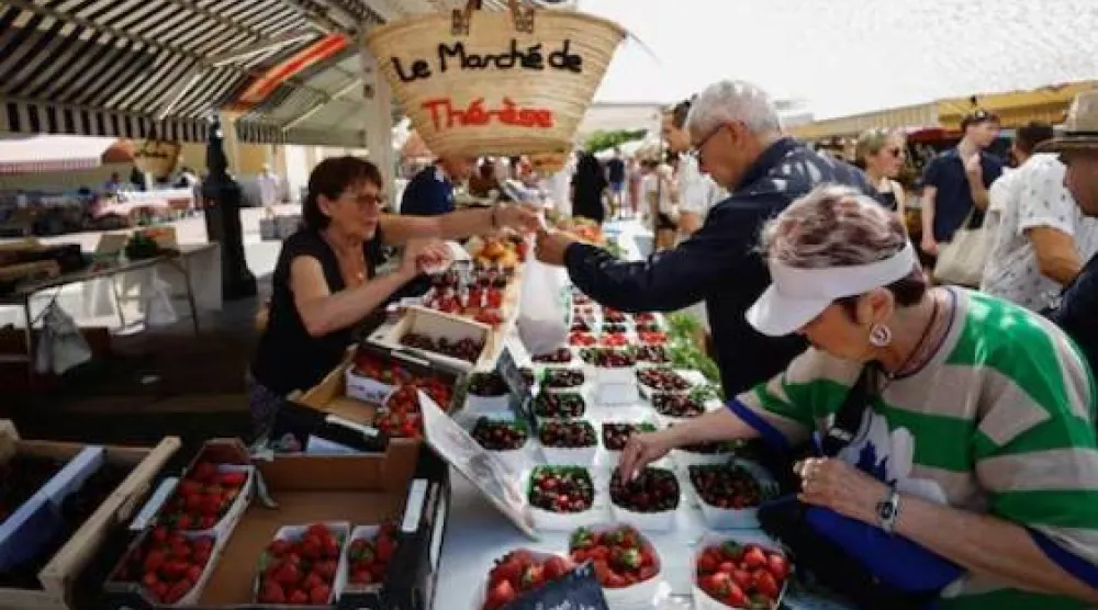 يتسوق المشترون الفواكه في سوق محلية بمدينة نيس في فرنسا (رويترز)