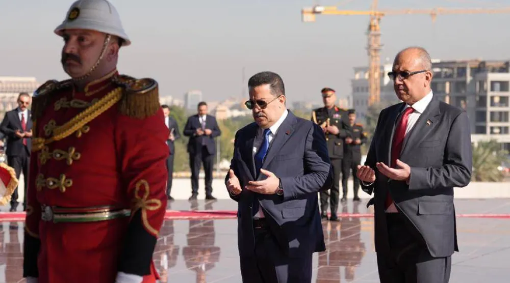 رئيس حكومة تصريف الأعمال محمد شياع السوداني ووزير الدفاع ثابت العباسي يقرآن الفاتحة أمام نصب الجندي المجهول في بغداد (المكتب الإعلامي لرئاسة الوزراء)