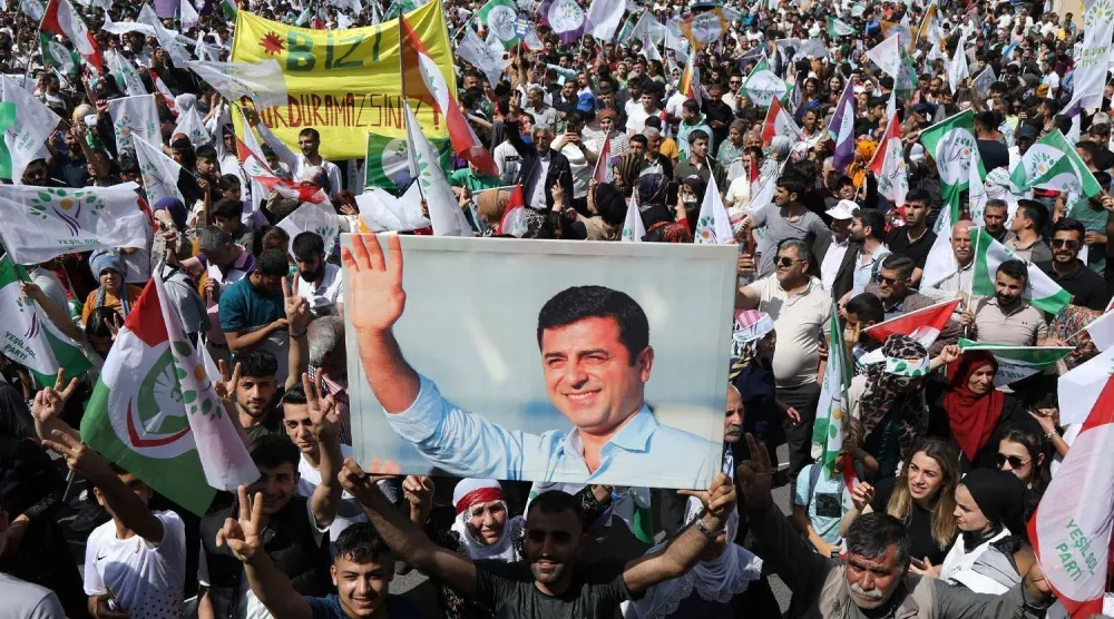 أكراد يرفعون صورة للسياسي الكردي صلاح الدين دميرطاش خلال مظاهرة في جنوب شرقي تركيا للمطالبة بإطلاق سراحه (رويترز)