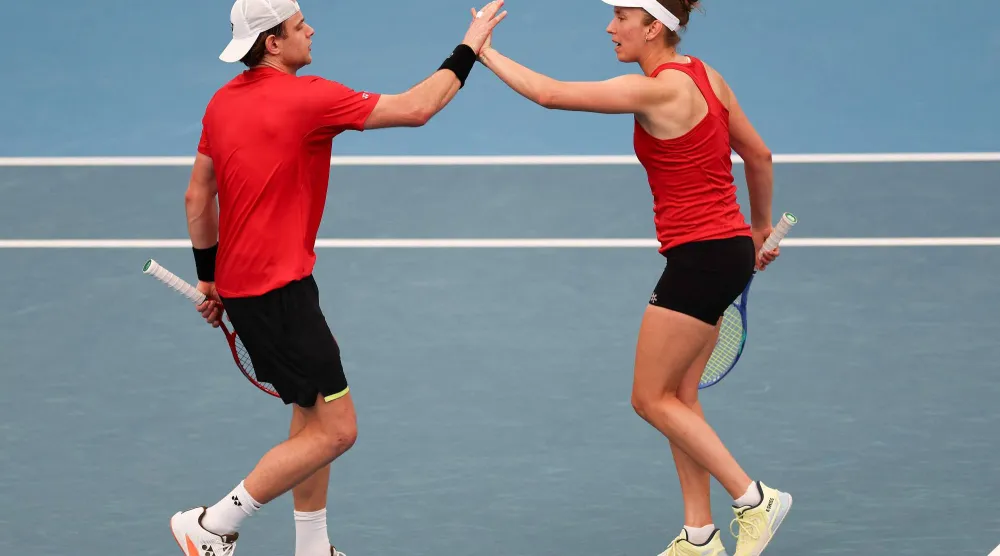 ثنائي بلجيكا زيزو بيرغيس وإليز ميرتنز يحتفلان بالفوز على كندا (أ.ف.ب)