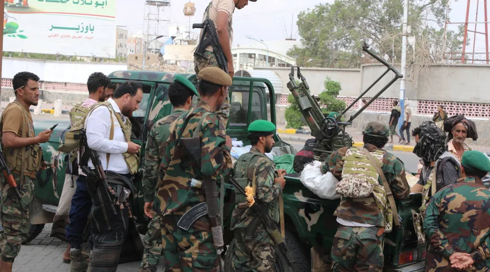 
تجمّع عناصر من الشرطة حول مركبة عسكرية عند نقطة تفتيش في عدن أمس (رويترز)