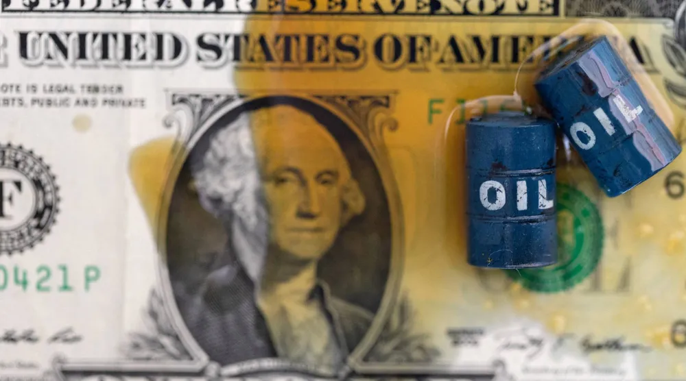 النفط ونماذج مصغرة لبراميل النفط وأوراق نقدية من فئة الدولار الأميركي (رويترز)