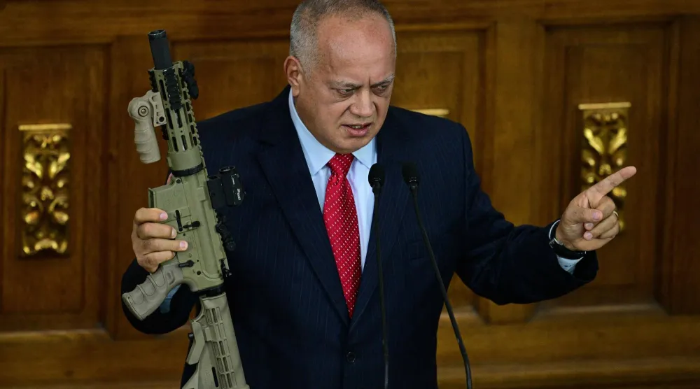 وزير الداخلية الفنزويلي ديوسدادو كابيلو يحمل بندقية أميركية الصنع خلال حديثه في جلسة بالجمعية الوطنية في كاراكاس (أ.ف.ب)