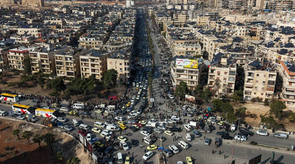 صورة جوية تُظهر سكاناً سوريين في سيارات يصطفون للفرار من حيي الشيخ مقصود والأشرفية (أ.ب)