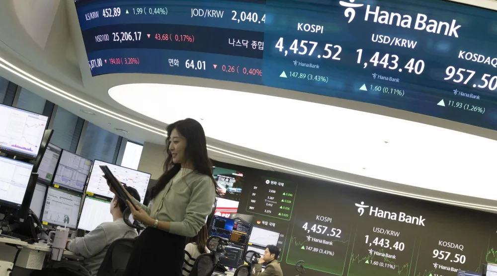 يعمل متداول كوري جنوبي أمام شاشات تعرض مؤشرات الأسهم في بنك «هانا» في سيول (إ.ب.أ)