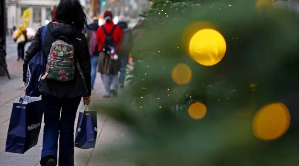 متسوقون خارج متجر «كاوفهاوس ديس ويستنس» خلال موسم عيد الميلاد في برلين (رويترز)