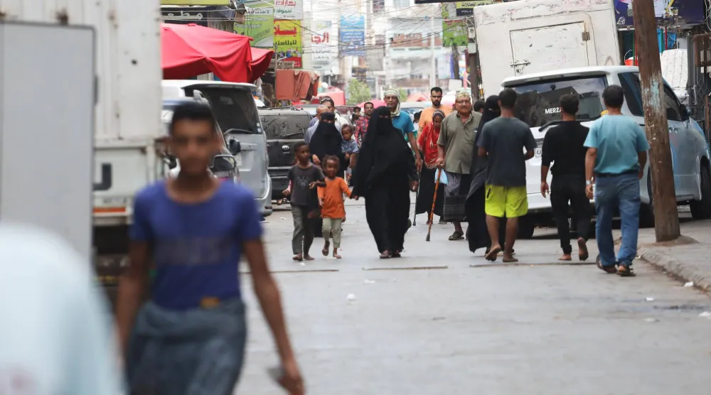 يمنيون يسيرون في سوق بمدينة عدن (إ.ب.أ)